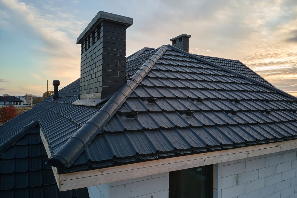 Toit résidentiel moderne au coucher du soleil avec cheminées en maçonnerie