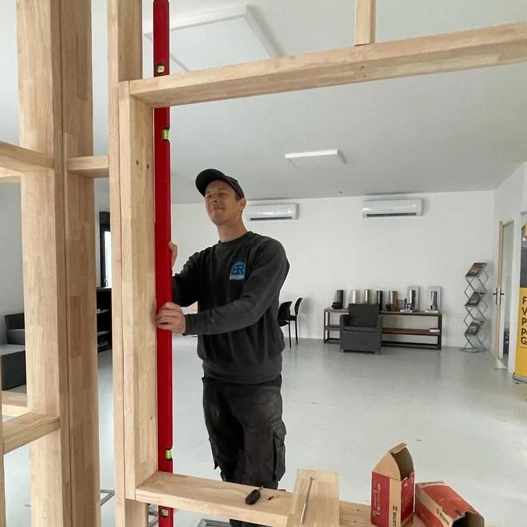 Ouvrier de construction installant des feuilles d'isolation en polystyrène sur le mur de façade de la maison pour la protection thermique