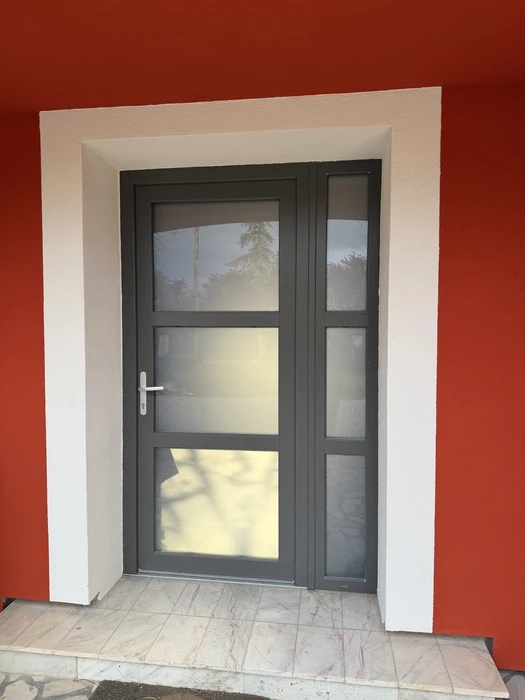 Façade extérieure d'une maison individuelle à enduit clair, vue en contre-plongée