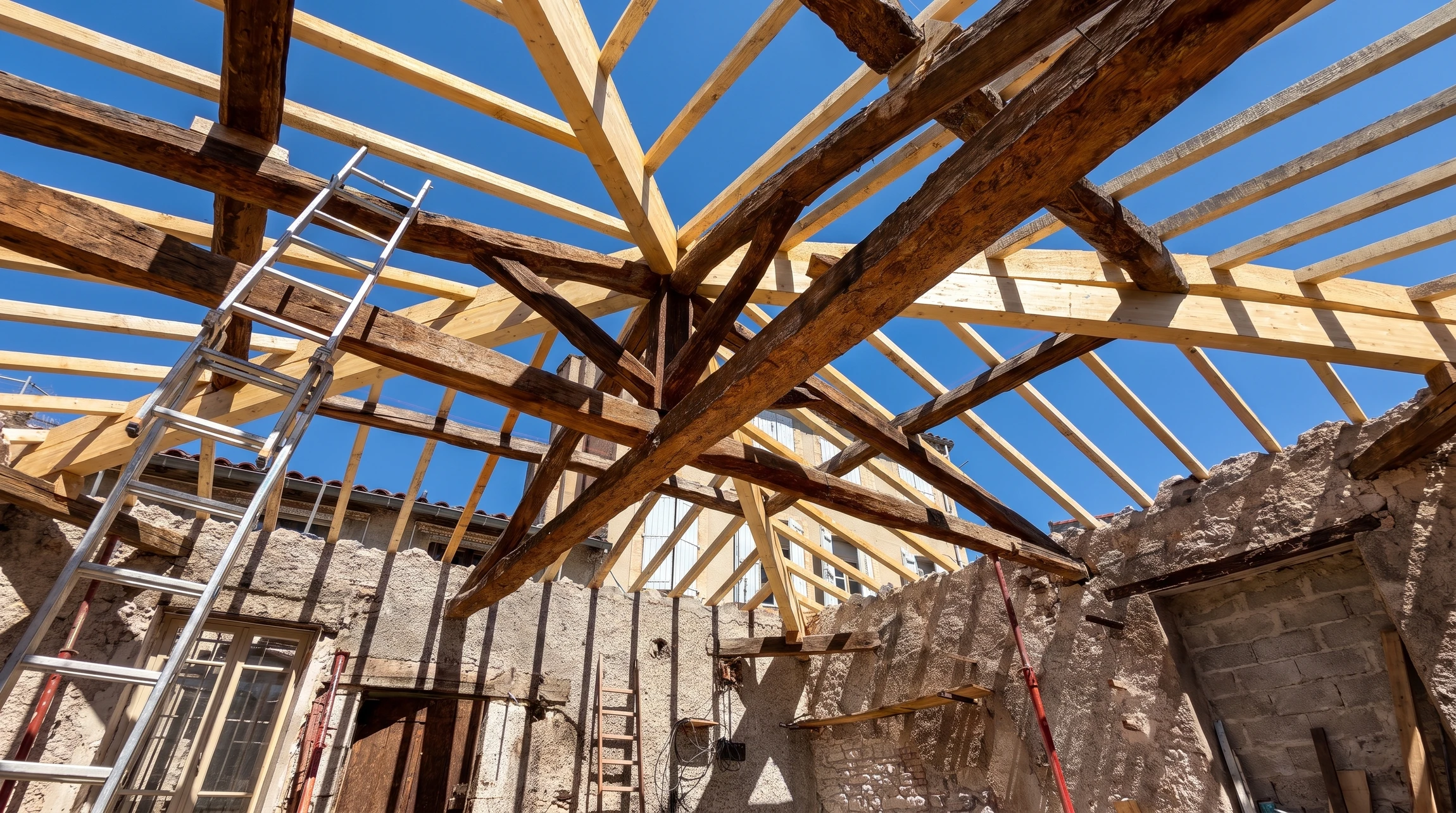 Combles aménageables en cours de rénovation avec charpente bois apparente et isolation sous-toiture
